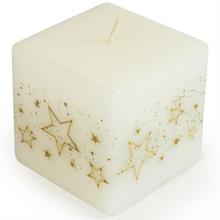 Biela sviečka v tvare kocky so zlatými hviezdami.