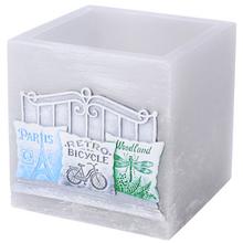 Sivý dekoračný lampáš s vankúšikmi a motívom bicykla.