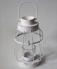 Biely svietnik z kovu a skla v tvare lucerny.