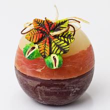 Ovocná sviečka s gaštanovým dizajnom a listami.