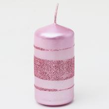 Ružová vianočná sviečka s glitrami a pruhmi.