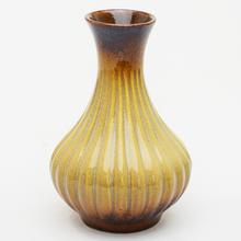 Hnedá keramická váza s pruhovaným dizajnom.