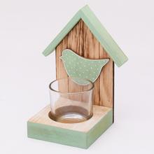 Drevený svietnik v tvare domčeka s modrým vtáčikom.