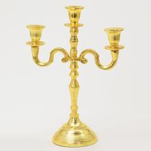 Zlatý svietnik s tromi ramenami a výškou 30 cm.