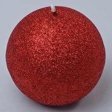 Červená glitrová sviečka v tvare guľe.