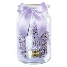 Fialová vonná sviečka v skle s mašľou.