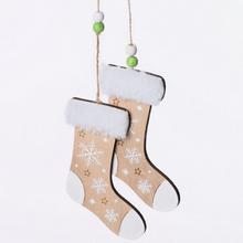 Drevené ponožky s bielou snehovou vločkou a zelenými korálkami.