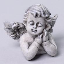 Smutný anjel so sklopenými očami a zloženými rukami.