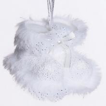 Biele čižmy so zlatými detailmi na vianočnej dekorácii.