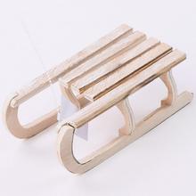 Drevené sane v prírodnej farbe, malé, s rozmermi 16x8x5,5 cm.