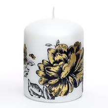 Biela sviečka s matným povrchom a kvetinovým vzorom.