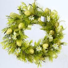 Zeleno žltý veniec s vajíčkami a kvetmi.