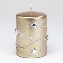 Zlatá vianočná sviečka s hviezdami a ozdobnými guľôčkami.