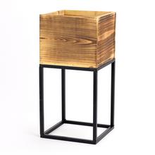 Hnedý obal na kvety s čiernym podstavcom.