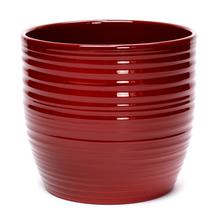 Červený keramický obal na kvetináče s pruhovaným dizajnom.