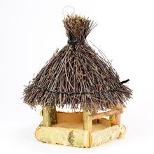 Krmítko z dreva a prútia s doškovou strechou.