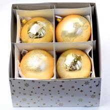 Sada štyroch zlatých sklenených vianočných guľí s rôznymi vzormi.