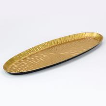 Zlatá oválna podložka s dekoratívnym vzorom.