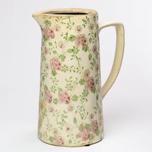 Keramický džbán s ružovým kvetinovým vzorom.