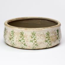 Keramický obal v tvare kruhu so zeleným vzorom.