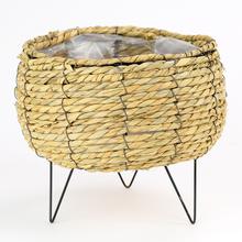 Hnedý obal na rastliny z prútia s čiernymi nohami.