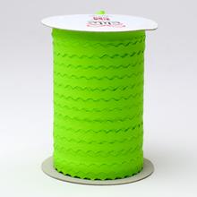 Zelená papierová stuha s vlnkovaným okrajom na cievke.