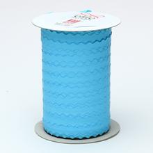Modrá papierová stuha s vlnkovým okrajom na cievke.