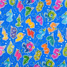 Modrý baliaci papier s farebnými balónmi a číslami.