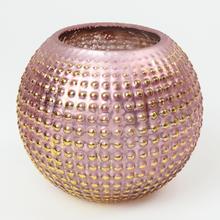 Sviečka v sklenenom svietniku fialovej farby.