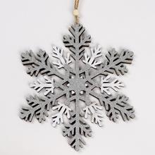 Závesná vločka z dreva v striebornej farbe.