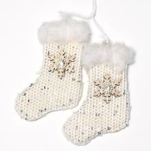Biele závesné ponožky s dekoráciou a snehovou vločkou.
