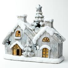 Vianočný svietnik v tvare domčeka so snehom a hviezdami.