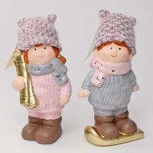 Dve keramické postavičky detí v zimných čiapkach a šálach.