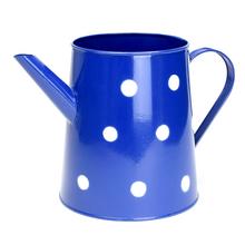 Modrá kovová váza s veľkými bielymi bodkami.