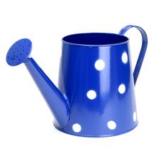 Modrá kovová váza s veľkými bielymi bodkami.