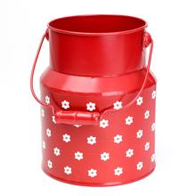 Červená kovová váza s kvetinovým vzorom.