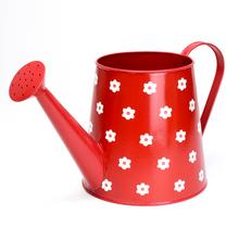 Červený kovový obal na kvety s bielymi kvetmi.