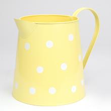 Žltý džbán s veľkými bielymi bodkami.