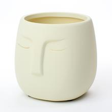 Biely kvetináč s otvorom a tvárou.