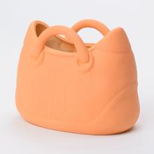 Oranžový keramický obal v tvare kabelky.