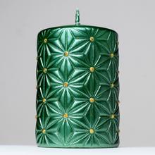 Zelená vianočná sviečka s ornamentom.