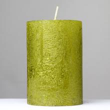 Zelená sviečka s glitrami, valcového tvaru.