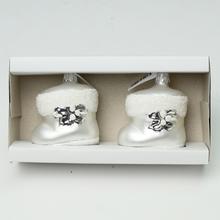 Biele sklenené vianočné gule vo forme papučiek.