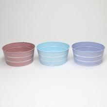 Kovové nádoby v troch farbách s pruhmi.