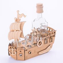 Drevená loď s pohármi a fľašou.