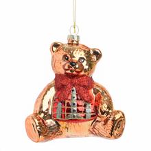 Sklenená vianočná guľa v tvare medvedíka s červeným šálom.