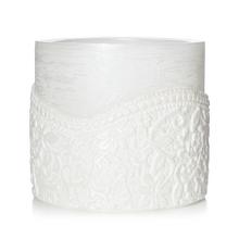 Biely okrúhly svietnik s dekoratívnym vzorom.