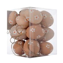 Béžové plastové vajíčka s kvetinovým vzorom v priehľadnej krabičke.