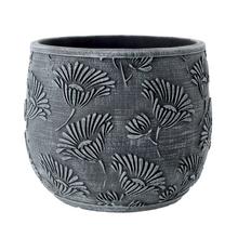 Šedý cementový obal s kvetinovým vzorom.