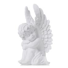 Biely smútočný anjel sediaci s krídlami.